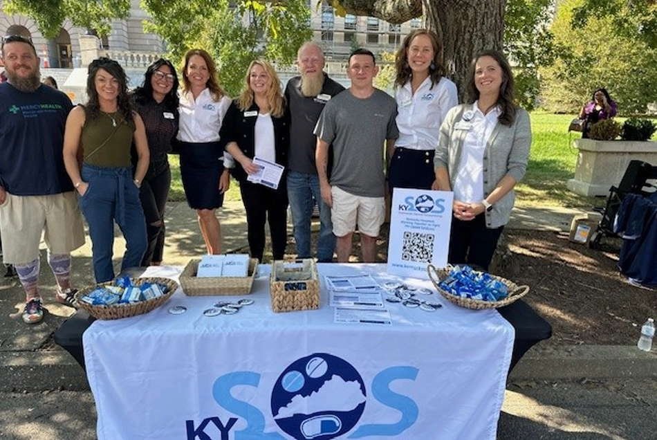 Pictured left to right are KYSOS pharmacy team members and peer support specialists present for the event (left to right): Pat Bailey (Mercy Health - Marcum and Wallace Hospital), Nikki Howard (Harrison Memorial Hospital), Robyn Helton (CHI Saint Joseph Health - Saint Joseph Mt. Sterling), Emily Henderson (KYSOS), Tabitha Hardin (The Medical Center at Bowling Green), Will Caylor (Mercy Health - Lourdes Hospital), Mary Beth Ecken (KYSOS), and Shanna Jaggers (KYSOS).